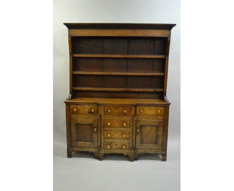 Early 19th Century oak and fruitwood Anglesey dresser, the boarded shelf back above a breakfront base with six drawers and tw