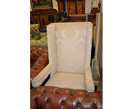 Late 19th or early 20th Century walnut upholstered wing armchair in 17th Century style, the cream damask back, seat and arms 