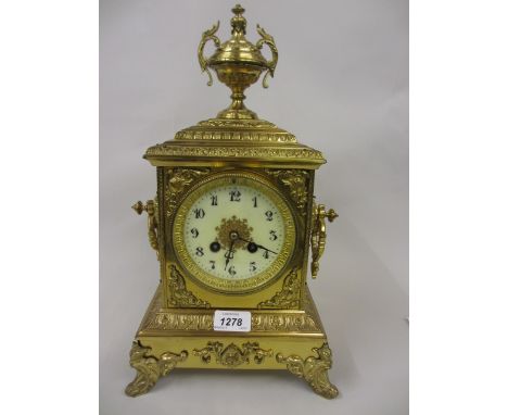 19th Century gilt brass mantel clock with urn surmount, the enamel dial with Arabic numerals, the two train movement striking