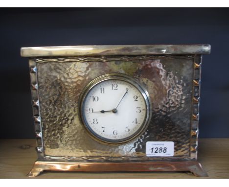 Early 20th Century beaten silver plated on copper mantel clock, the enamel dial with Arabic numerals