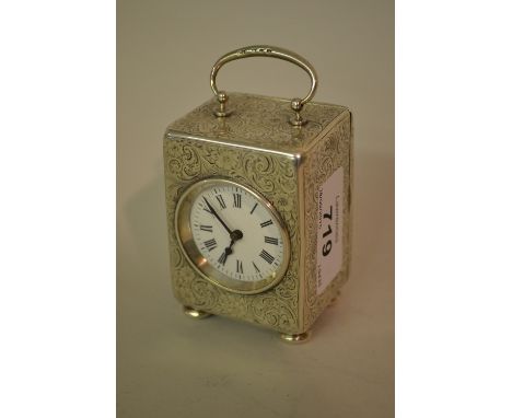 Early 20th Century Birmingham silver dressing table clock, the floral engraved case enclosing an enamel dial with Roman numer