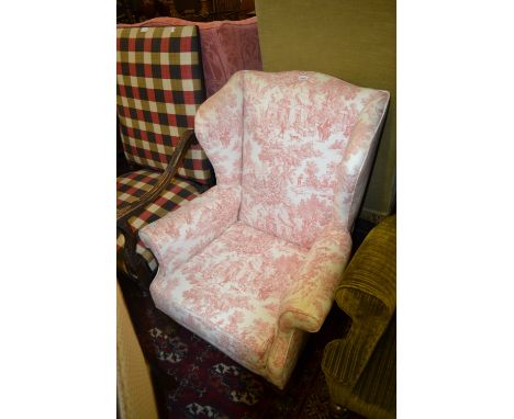 Early 20th Century upholstered wing armchair in 18th Century style, covered in a pink toile du jour style fabric and raised o