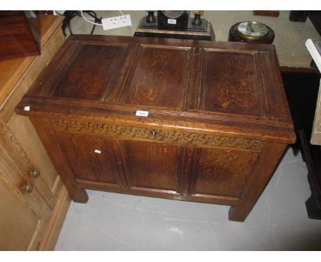 Small 17th Century oak coffer, the plank top above a carved frieze and three panel front on stile supports