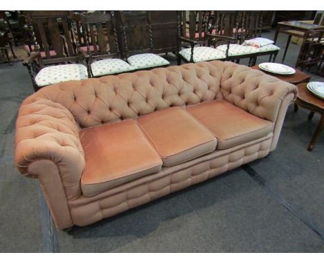 An Edwardian button back Chesterfield three seater sofa on bun feet and castors, 198cm long x 68cm tall x 86cm deep