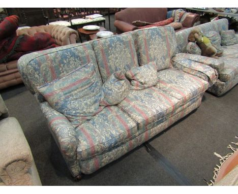 An early 20th Century sofa with feather filled cushions, floral silk upholstery