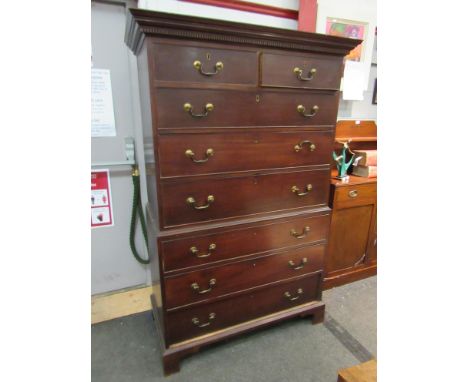 A George III mahogany chest on chest, the dentil moulded top over two short and six long drawers, swan neck handles, bracket 