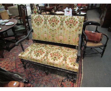 An 18th Century ebonised carved walnut two seater country house sofa on turned supports and stretchers, 110cm tall x 123cm wi