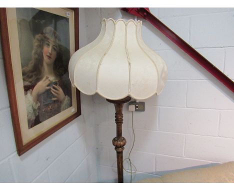 A gilded standard lamp with shade