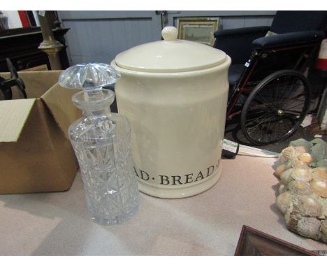 A decanter with stopper and a lidded ceramic bread bin