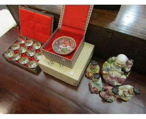 A laughing Buddha with five children, a box containing Chinese tea cups and a single tea bowl