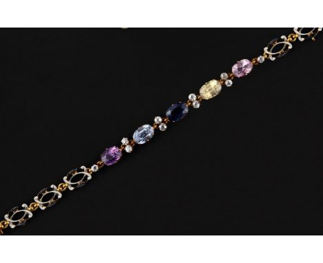 mounted with five different coloured oval-shaped sapphires, each divided by pairs of rose-cut diamonds, the scrolling gold li