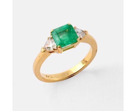 the square step-cut emerald weighs 1.45 carats and is set with a trilliant-cut diamond to each shoulder, in 18ct yellow gold.