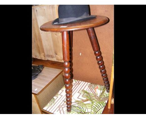 A circular wine table on bobbin supports 