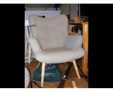A contemporary button back easy chair upholstered in grey 