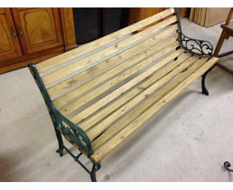 A wrought iron end garden bench with pressure treated wooden slats