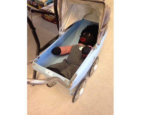 A vintage blue tin dolls pram with a Golly rag doll and a vintage Tri-ang horse rocker.