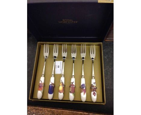 A boxed set of Royal Worcester Evesham gold pastry forks with ceramic handles.