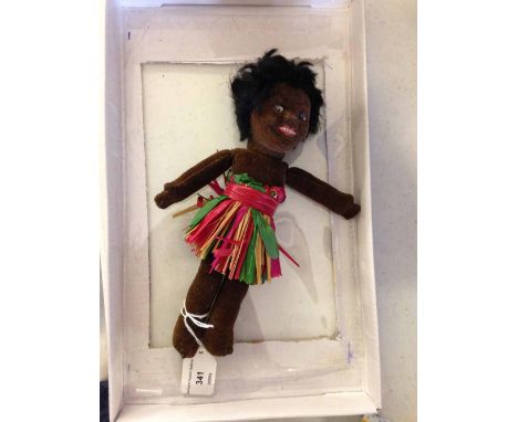 A vintage Norah Wellings black rag doll in a grass skirt.