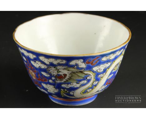 A small Chinese porcelain bowl, enamelled with scaly dragons on a blue ground cloud background, red painted seal mark, 10cm d