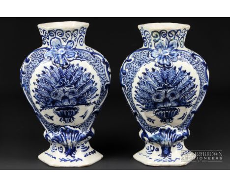 A pair of Dutch delftware blue & white vases, of flattened baluster form moulded with 'C' scroll reserves enclosing a peacock