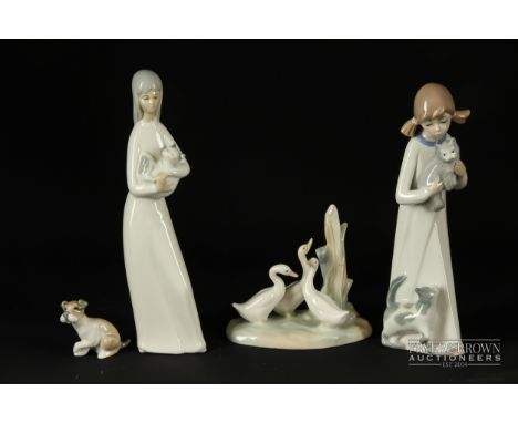 A Nao by Lladro figural group of three geese and some reeds; two other Spanish figures, both of women holding cats; and a Lla