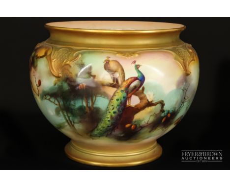 A large royal Worcester jardiniere, signed W.E. Jarman, painted with peacocks amidst pine trees beneath 'C' scroll trellis mo