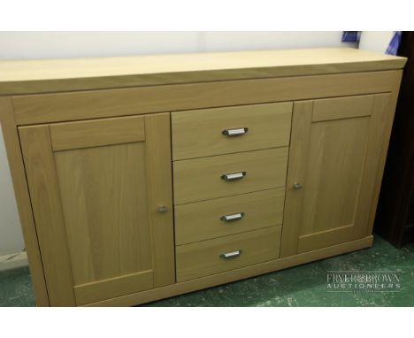 A contemporary light oak veneer sideboard, four central drawers flanked by cupboards with one shelf, soft close doors and dra