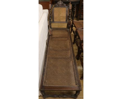 A Carolean style walnut and canework day bed, W.160cm