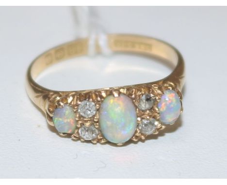 An early 20th century 18ct gold white opal and diamond half hoop cluster ring, size 0.