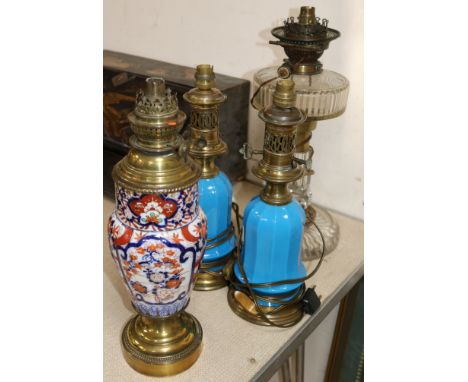 A pair of blue glass oil lamps, a cut glass oil lamp, all converted to electricity and an Imari based oil lamp