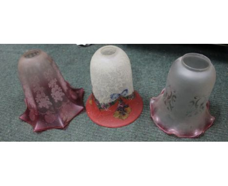 A box containing three ruby glass decorative etched lampshades 