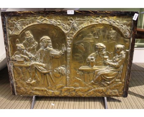 A LARGE PRESSED BRASS PANEL of cellar revelry, in plain wooden frame fashioned as a fire screen 