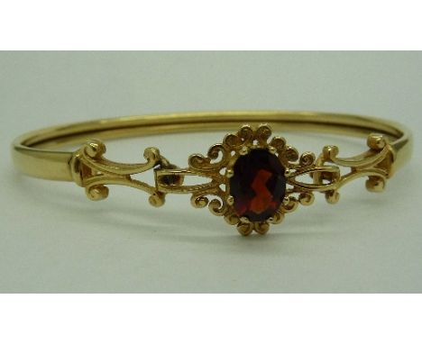 A 9ct gold and garnet bangle, weight 6.2g