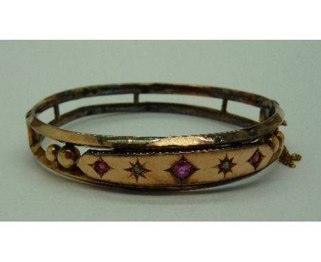A 9ct gold bangle set with old cut diamonds and red stones, weight 11.8g