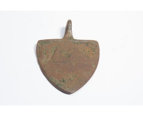 Medieval heraldic harness pendant. Circa 13th century CE. Copper-alloy, 16.55g. 51mm. A shield-shaped pendant displaying a pa