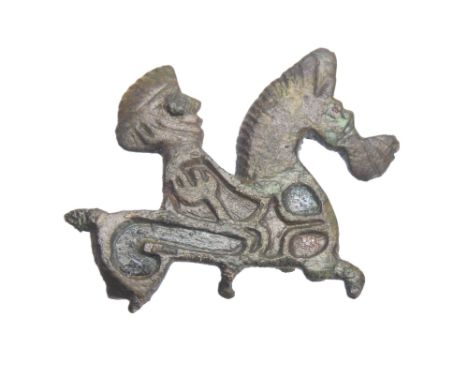 Roman zoomprphic plate brooch. Circa 1st century CE. In the form of a horse and rider. The decorative cells have traces of bl