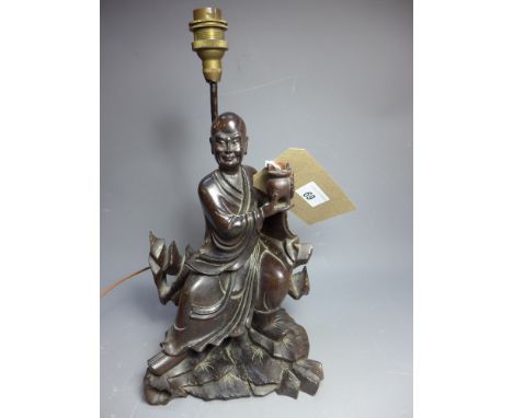 SOLD IN TIMED AUCTION A Chinese carved wood figure of a man holding a koro, converted to a table lamp. H-34cm W-17cm D-13cm