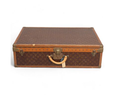 LOUIS VUITTON - a hard suitcase/trunk with monogrammed fabric cover, leather edging, brass locks and mounts with LV monogram 
