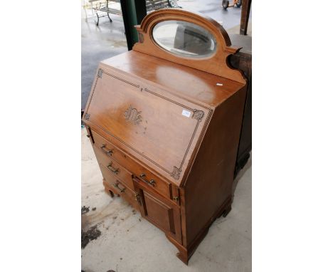 Light wood bureau with carved fall front above single drawer, two short drawers and a cupboard door 