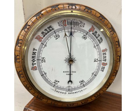 An oak framed aneroid barometer, of circular form, inscribed Barry &amp; Sons Cardiff