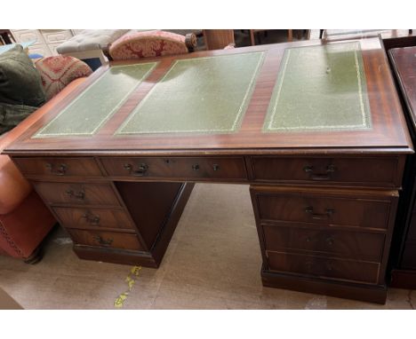 A 20th century mahogany pedestal desk, with three leather inset panels above a central drawer and two pedestals of drawers 