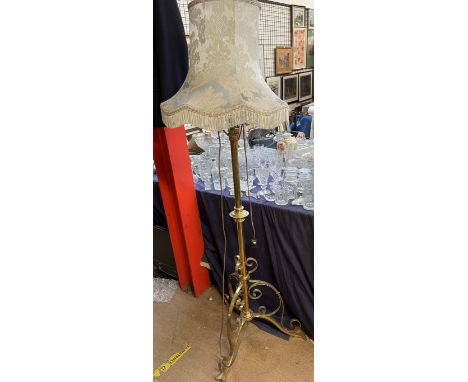 A brass standard lamp with a scrolling base 