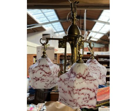 A brass ceiling light with a set of three shaped glass shades