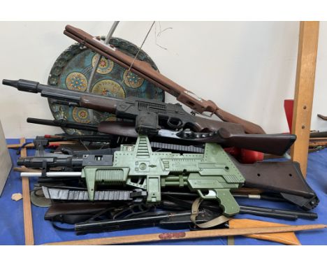 A collection of model guns, bows etc 