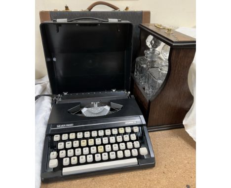 An oak cased tantalus together with a Silver Reed typewriter  and a briefcase 