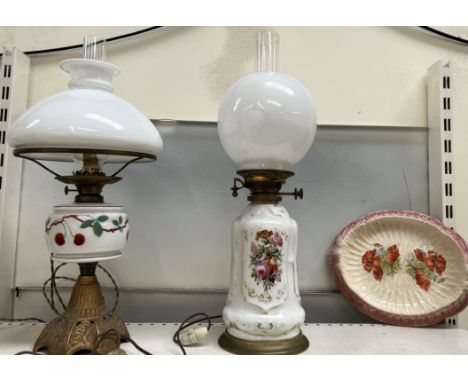 A porcelain oil lamp, painted with flowers together with another oil lamp (converted) and a poppy decorated pottery dish