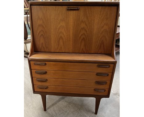 A mid 20th century teak bureau / drinks cabinet, with a sloping fall the interior with a single shelf above four long graduat