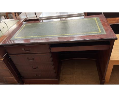 A reproduction mahogany desk, with a leather inset top, pull out slide and four drawers on a plinth