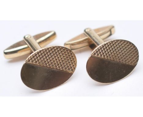 Pair of 9ct gold engine turned oval cufflinks, Birmingham 1986, with folding torpedo bar, gross weight approx. 8g 