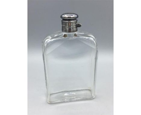 A glass flask with hallmarked silver top.